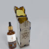 Small amber dropper bottle of Moroccan Argan Oil from Amigos Power with gold cap, placed on a light background.