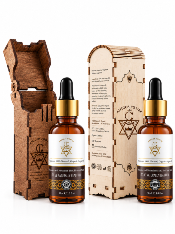 Amigos Power 100% natural Moroccan argan oil 30ml amber dropper bottles next to intricately carved protective wooden packaging boxes against a clean white background.